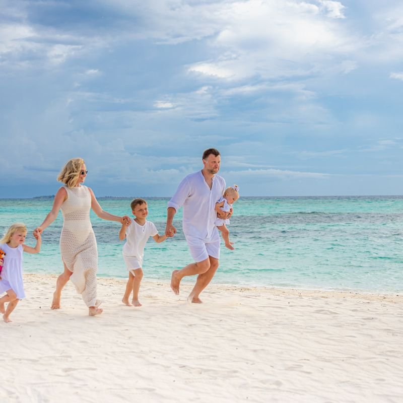 A family running into the sea on a beach holiday