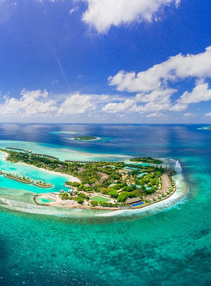 Aerial view of a tropical island ringed by a turquoise lagoon
